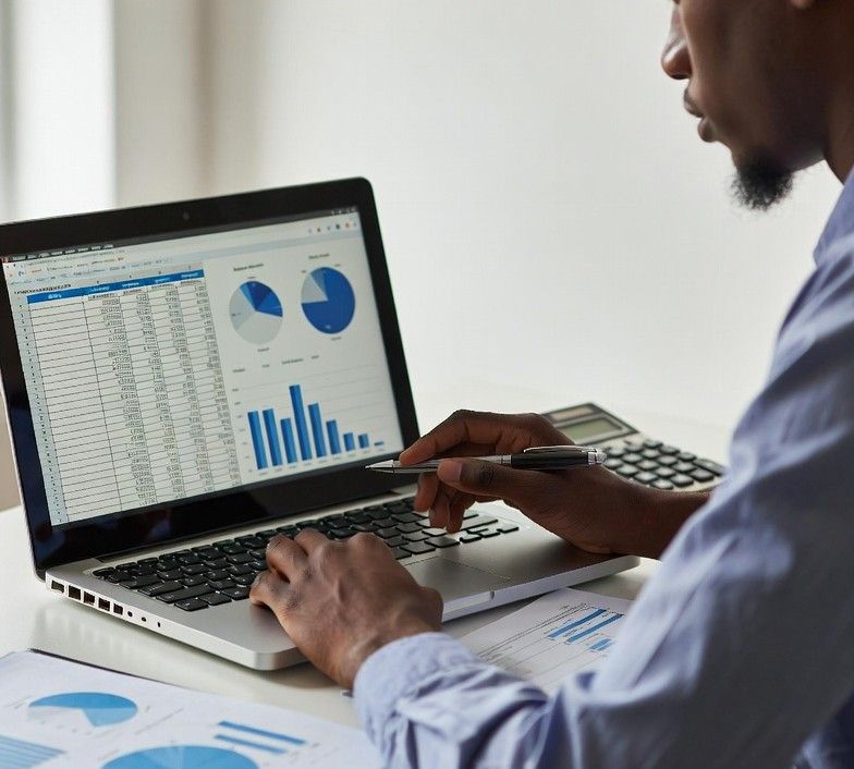 reviewing bank statements on a laptop with digital graphs